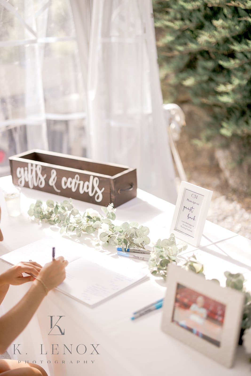 A decorated table displays a "gifts & cards" box, a guestbook, and greenery.