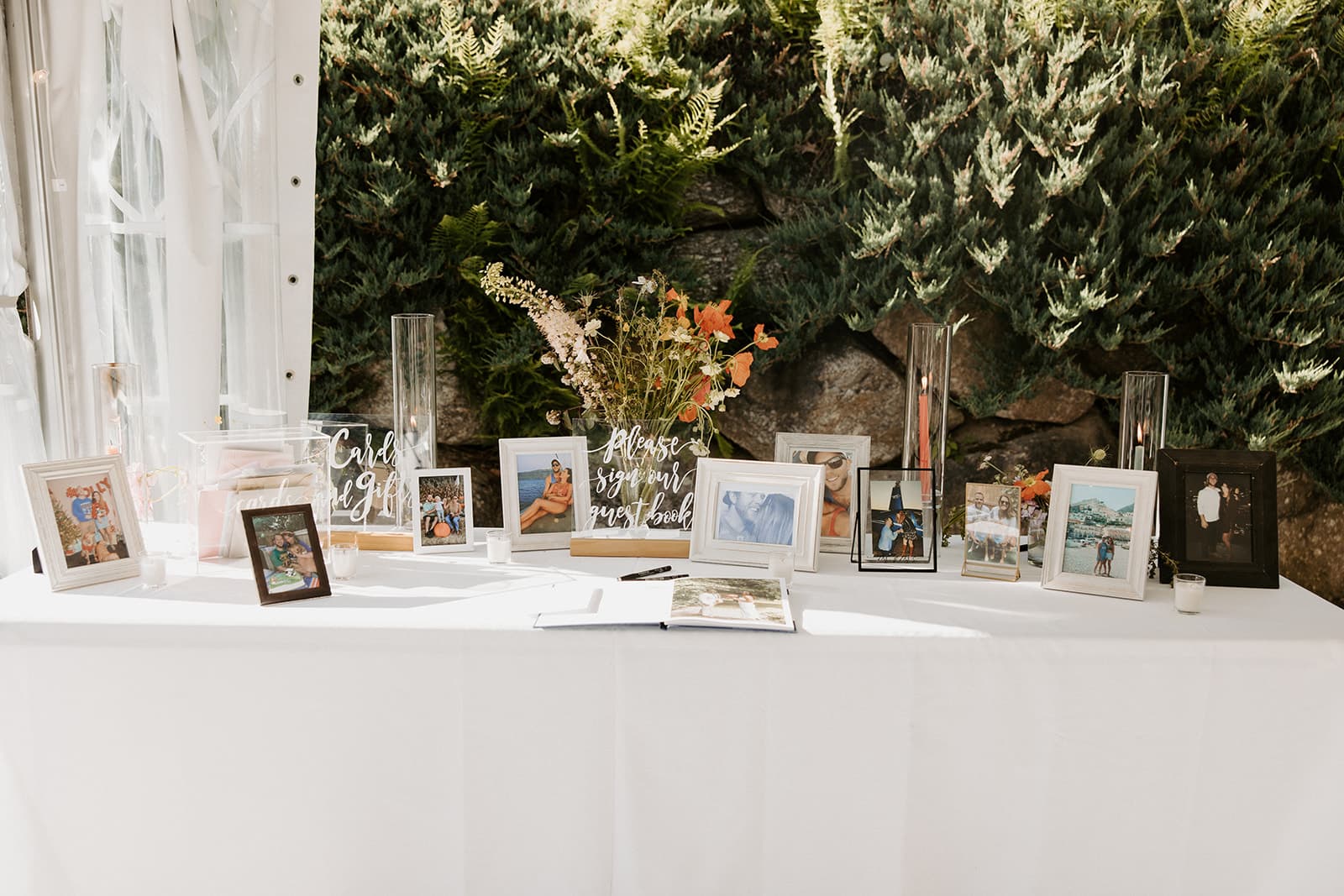 A decorated table displays framed photos, a guest book, and a sign for gifts.